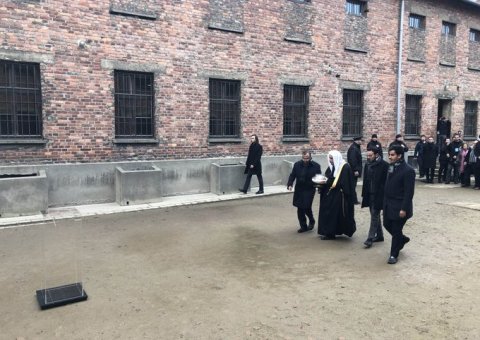 HE Dr. Mohammad Alissa lights a candle at the Wall of Executions in memory of all those killed there while visiting Auschwitz Museum with delegates from AJCGlobal